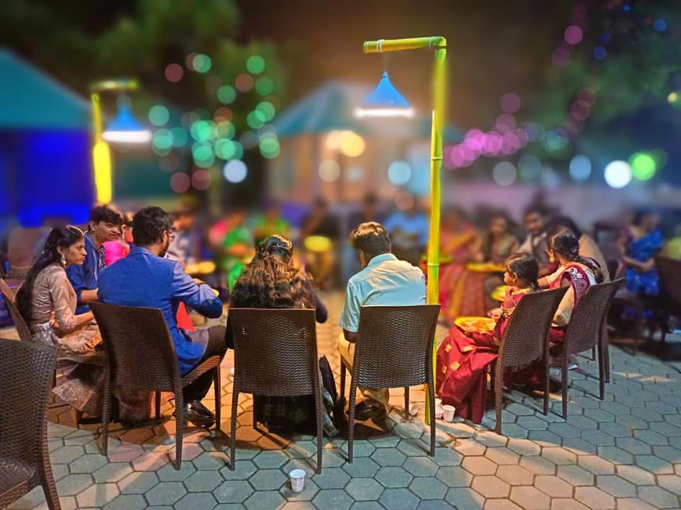 Guests dining under festive evening lights